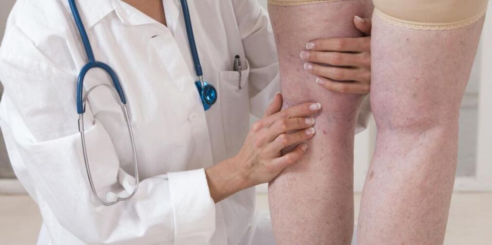 Il medico esamina le gambe del paziente